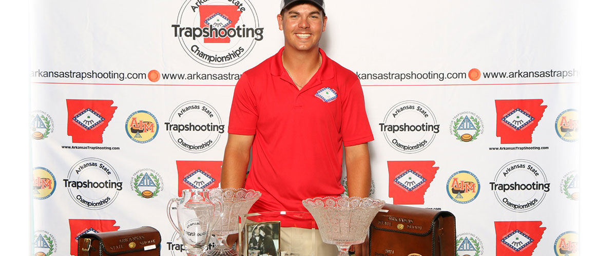 Logan Henry standing behind a table with his trophies