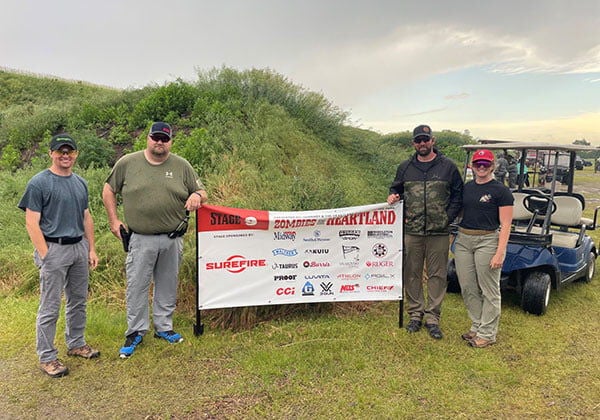 4 shooters standing next to a Zombie Heartland sign